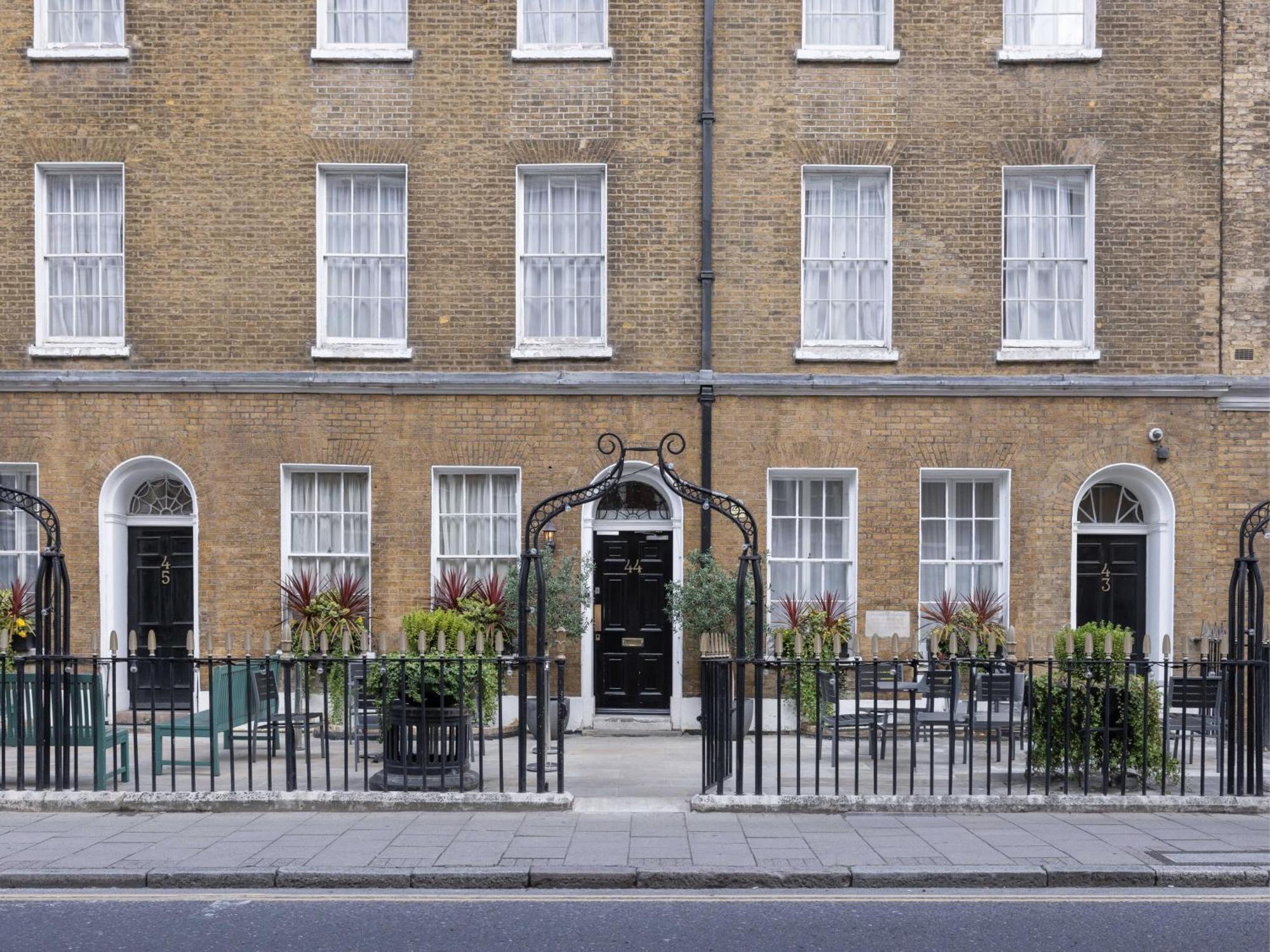 Montcalm Brewery Townhouse Hotel London Exterior photo The photo shows a row of three-story brick buildings, featuring a classic design with large windows and decorative ironwork. The buildings are painted in a muted yellow-brown color, typical of older urban architecture. In front of the buildings, ther