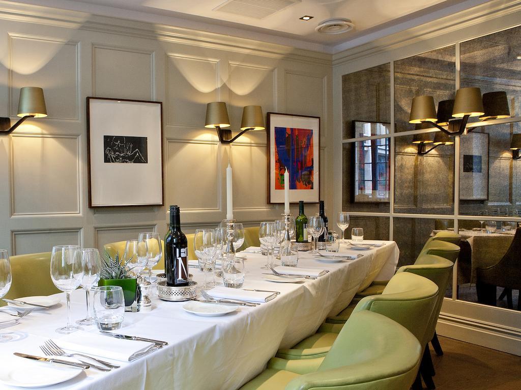 Montcalm Brewery Townhouse Hotel London Exterior photo The photo shows an elegant restaurant setting with a long dining table that is neatly set for a meal. The table is adorned with a white tablecloth, glassware, and silverware, indicating that it is prepared for a special gathering or event. 

Behind t