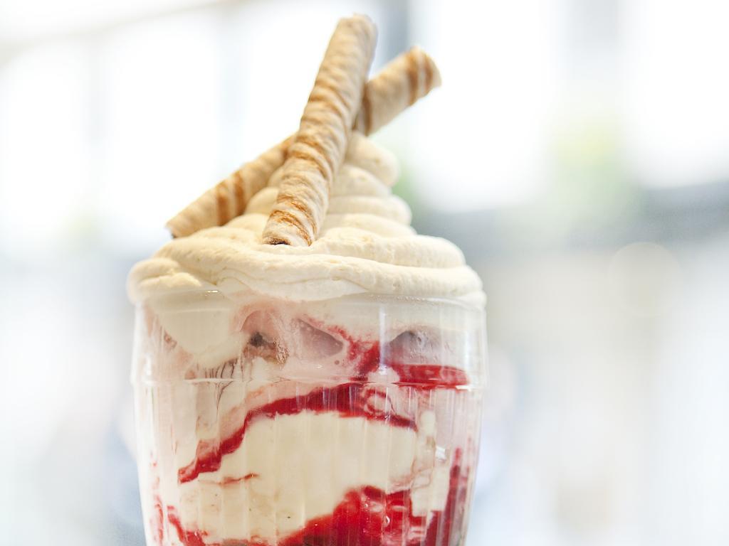 Montcalm Brewery Townhouse Hotel London Exterior photo The photo shows a delicious dessert in a clear glass dish. It features layers of creamy ice cream or whipped cream, swirled with a vibrant red fruit sauce. Topping the dessert are two rolled wafer sticks, adding a decorative touch. The overall presen